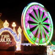 Foto de la feria de Julio en Valencia, se ve la entrada a la feria de noche y la noria iluminada con luces